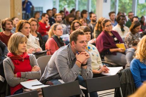 Sitzendes Publikum schaut aufmerksam zur Bühne