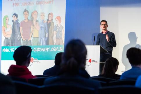 Der Vorstandsvorsitzende des Landesjugendring Berlin hält eine Rede bei einer Veranstaltung